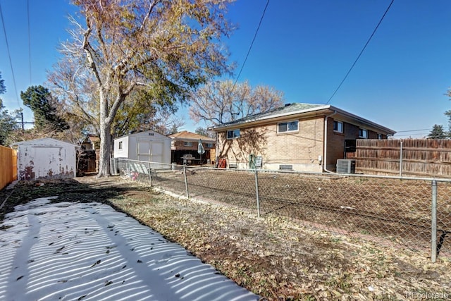 view of side of property with central AC and a storage shed