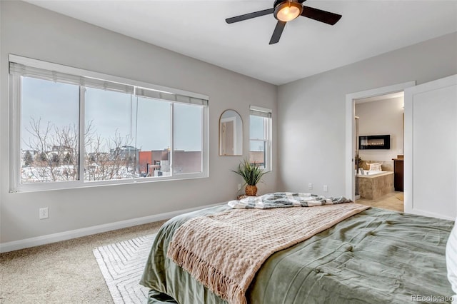 bedroom with light carpet, ensuite bath, a ceiling fan, and baseboards