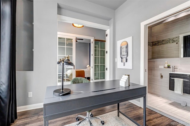 home office with baseboards and dark wood-style flooring