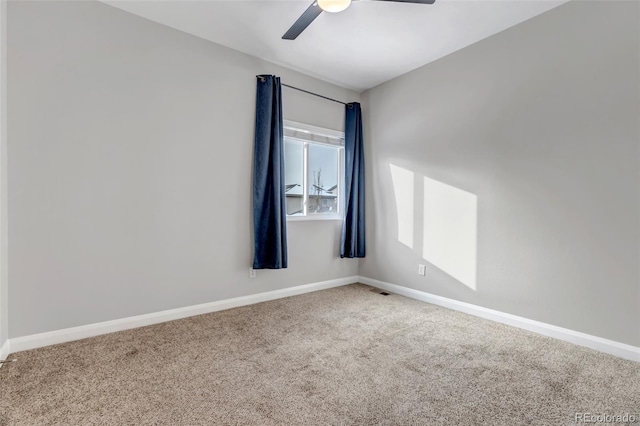 carpeted empty room with ceiling fan, visible vents, and baseboards