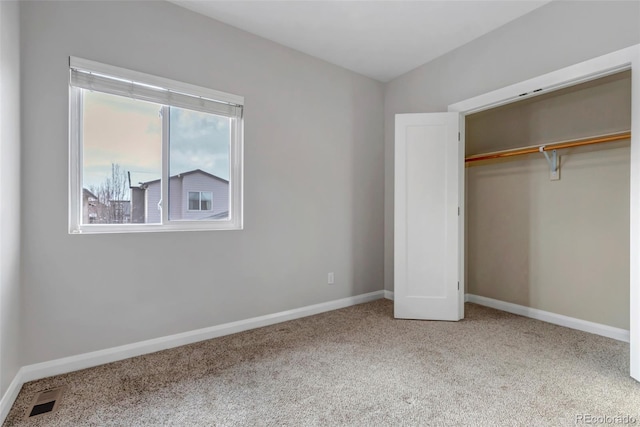 unfurnished bedroom with visible vents, a closet, baseboards, and carpet flooring