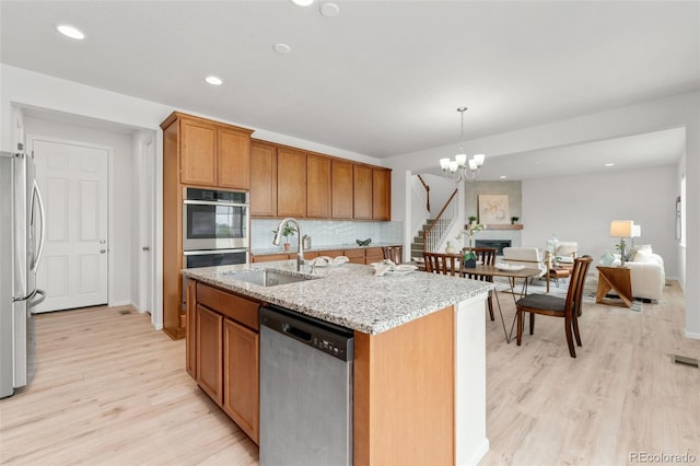 4666 S Malaya Ct, Aurora, CO 80015 - kitchen featuring appliances with stainless steel finishes, a sink, light wood-style floors, light stone counters, and recessed lighting