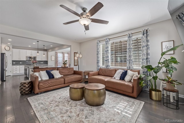 living room featuring ceiling fan and dark wood-style flooring