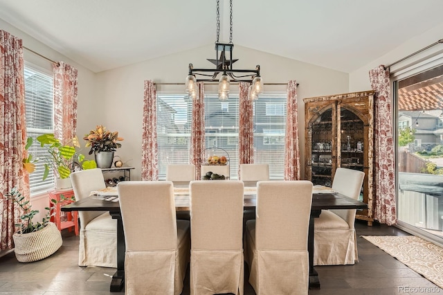 dining space featuring vaulted ceiling, dark wood-style floors, and a chandelier