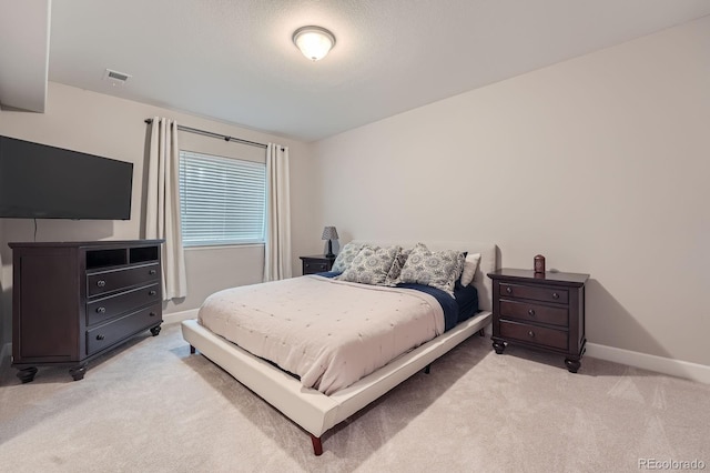 bedroom featuring light carpet, visible vents, and baseboards