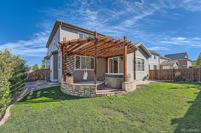 rear view of property featuring a hot tub, a fenced backyard, a yard, a pergola, and a patio