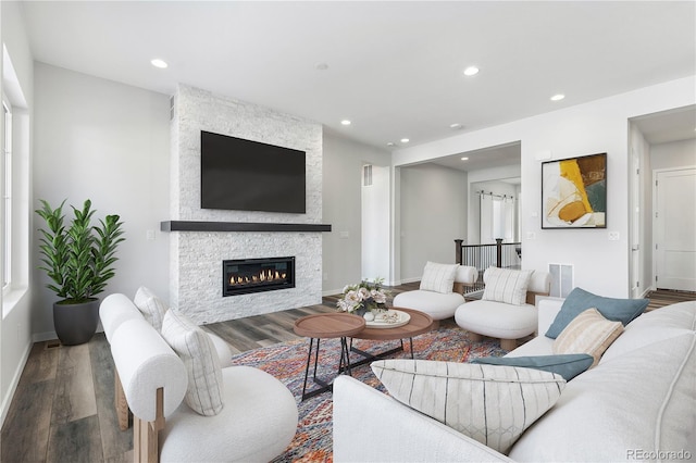 living room with a stone fireplace and hardwood / wood-style flooring