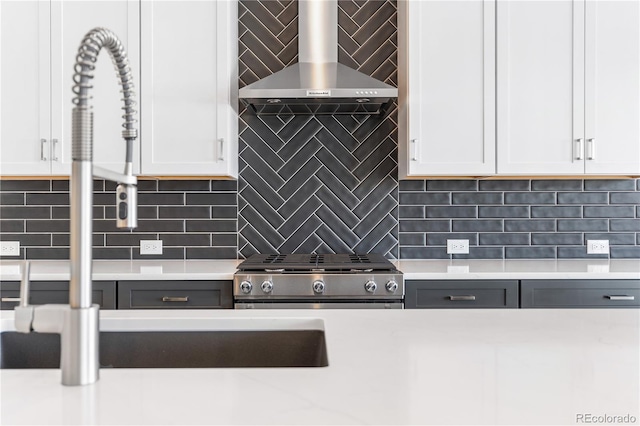 kitchen featuring decorative backsplash, white cabinets, and stove