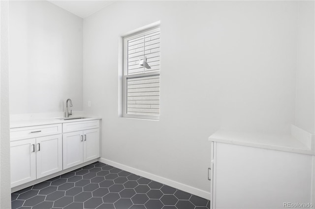 laundry room with dark tile patterned flooring and sink