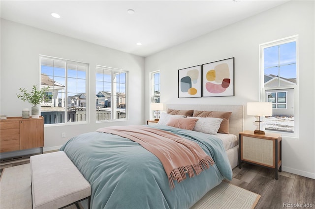 bedroom with dark wood-type flooring and multiple windows