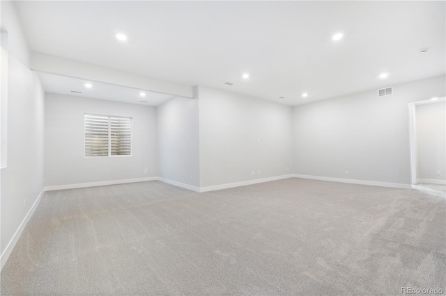 spare room featuring recessed lighting, visible vents, and light carpet