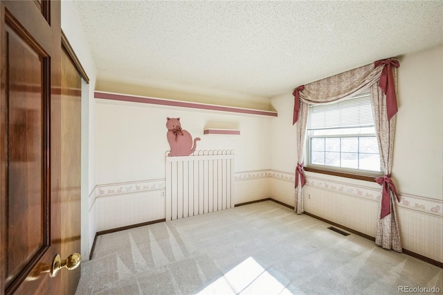 unfurnished bedroom with a textured ceiling and light carpet