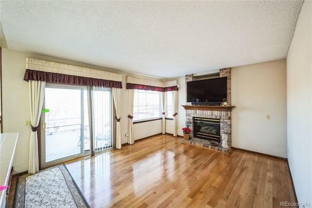 living room featuring a fireplace, a textured ceiling, and wood-type flooring