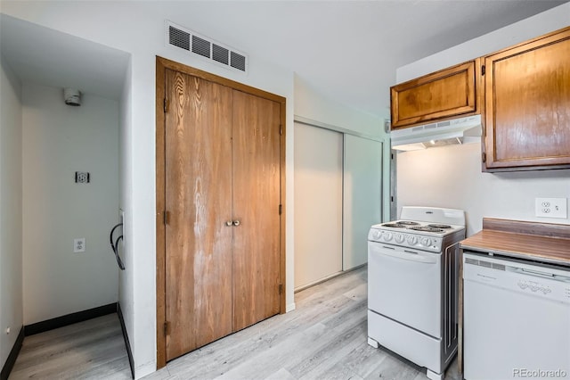 kitchen featuring white appliances and light hardwood / wood-style flooring