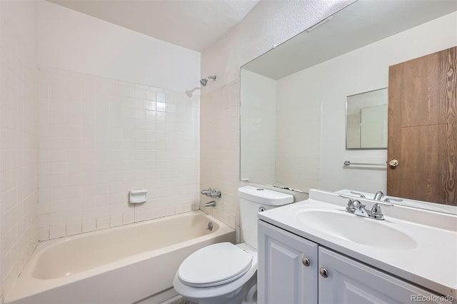 full bathroom featuring tiled shower / bath, vanity, and toilet