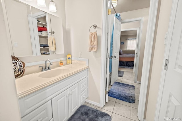1060 Alta Vista Dr, Craig, CO 81625 - ensuite bathroom with tile patterned floors, vanity, baseboards, and a walk in closet