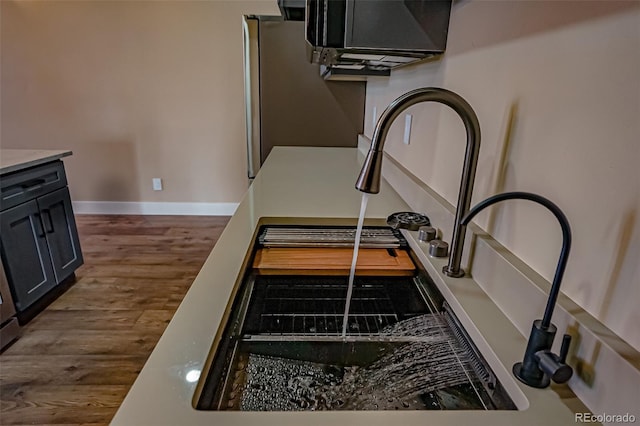 interior details featuring wood-type flooring and stainless steel refrigerator