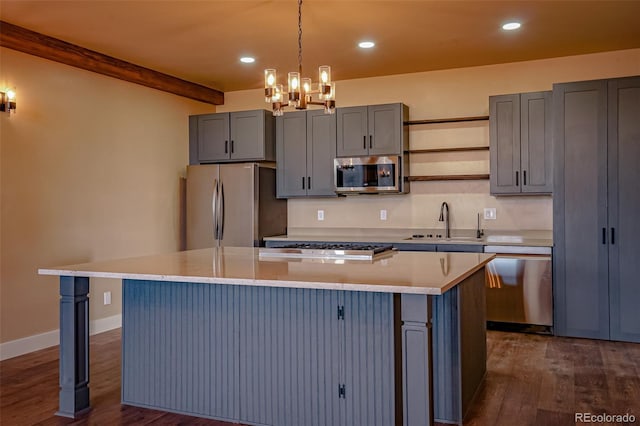 kitchen featuring appliances with stainless steel finishes, dark hardwood / wood-style flooring, sink, pendant lighting, and a kitchen island