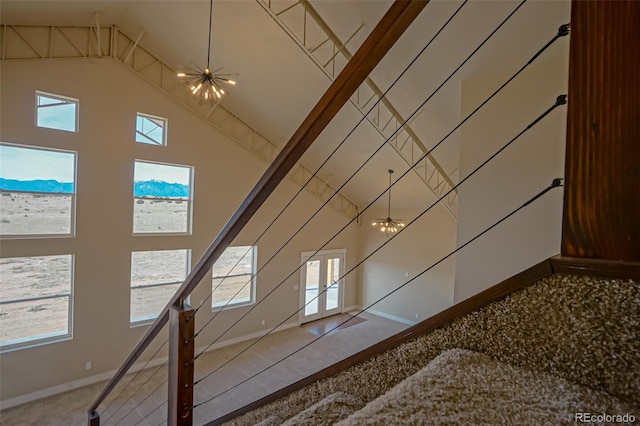 interior space with a notable chandelier, a healthy amount of sunlight, and a high ceiling