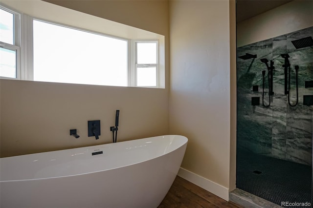 bathroom featuring independent shower and bath, a healthy amount of sunlight, and wood-type flooring