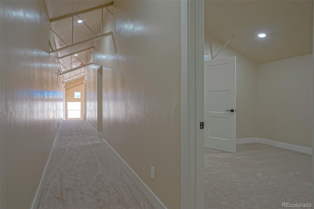 hallway with carpet flooring and vaulted ceiling