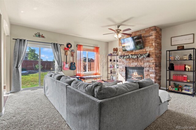 carpeted living room featuring ceiling fan and a brick fireplace