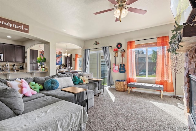 living room featuring light carpet and ceiling fan with notable chandelier