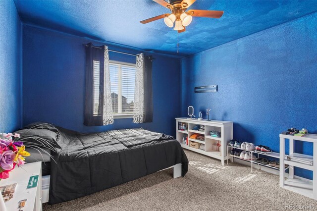 bedroom featuring ceiling fan, carpet flooring, and a textured ceiling