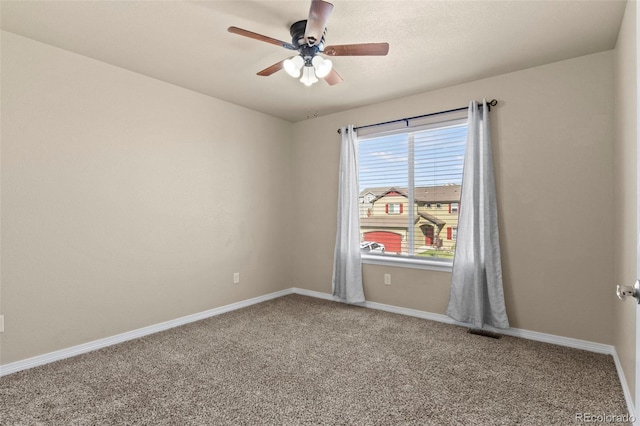 carpeted spare room featuring ceiling fan