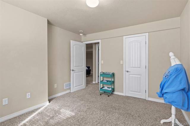 interior space with a textured ceiling and carpet