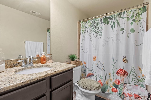 bathroom featuring toilet, walk in shower, and vanity