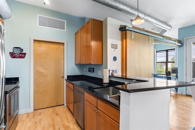 7700 E 29th Ave Unit 304, Denver, CO 80238 - kitchen featuring appliances with stainless steel finishes, light wood finished floors, and dark countertops