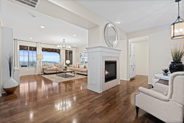 living room with dark wood-type flooring and an inviting chandelier