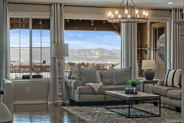 living room featuring baseboards, wood finished floors, a mountain view, and a chandelier