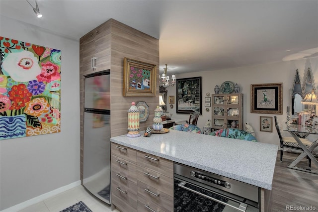 2 Adams St Unit 809, Denver, CO 80206 - kitchen with freestanding refrigerator, a peninsula, and a chandelier