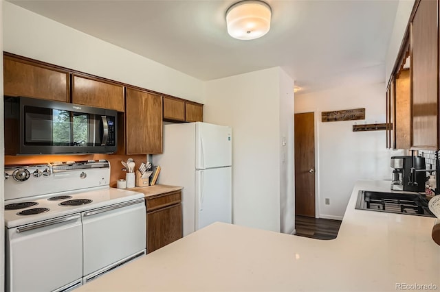 28669 Mountain View Rd, Conifer, CO 80433 - kitchen with white appliances, light countertops, brown cabinets, and wood finished floors