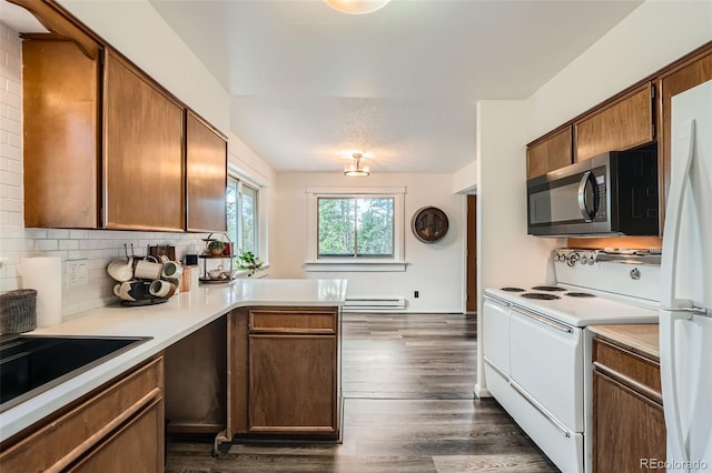 28669 Mountain View Rd, Conifer, CO 80433 - kitchen featuring white appliances, a peninsula, light countertops, dark wood-type flooring, and backsplash