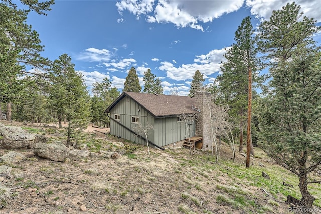 28669 Mountain View Rd, Conifer, CO 80433 - view of home's exterior featuring board and batten siding, a chimney, and roof with shingles