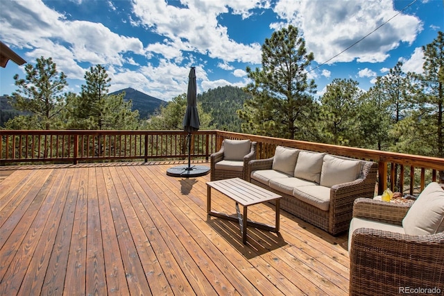 deck with an outdoor living space and a mountain view