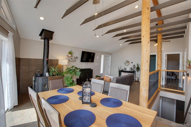 tiled dining room with vaulted ceiling with beams, tile walls, and a wood stove