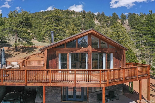 back of house featuring a wooden deck and a patio area