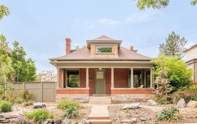 2845 Quitman St, Denver, CO 80212 - view of front of home with a chimney, a porch, a shingled roof, and brick siding