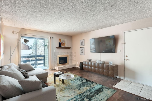 living room with a textured ceiling, a fireplace, and hardwood / wood-style floors