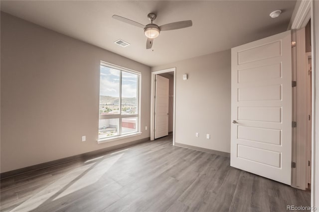 unfurnished bedroom with ceiling fan and light wood-type flooring