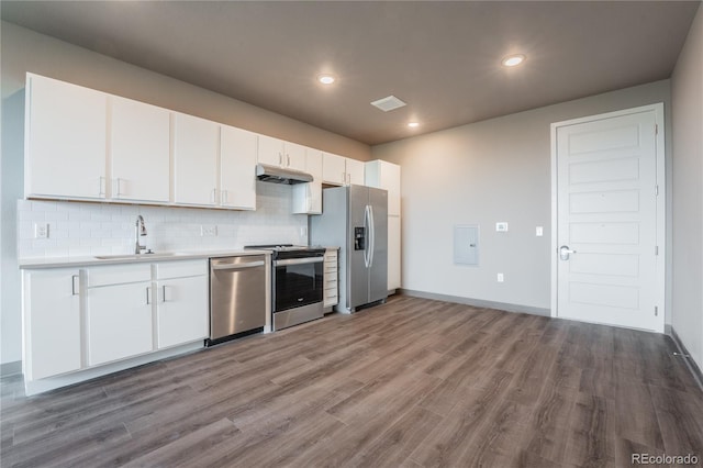 kitchen with sink, tasteful backsplash, light wood-type flooring, appliances with stainless steel finishes, and white cabinets