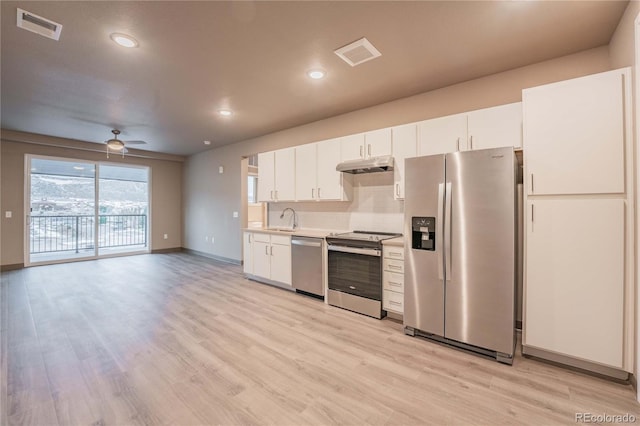 kitchen with appliances with stainless steel finishes, white cabinetry, sink, ceiling fan, and light wood-type flooring