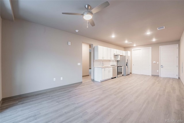 unfurnished living room with ceiling fan, sink, and light hardwood / wood-style floors