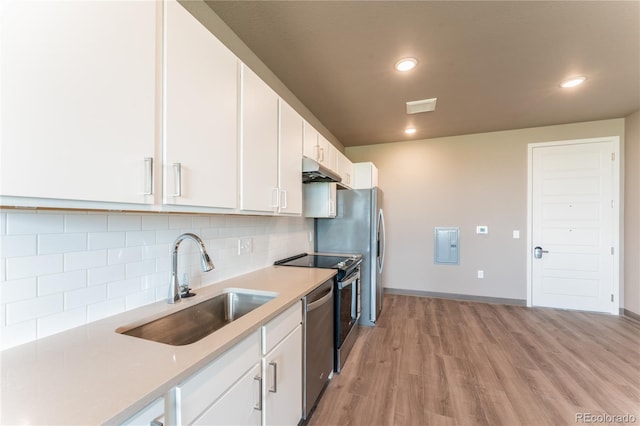 kitchen featuring sink, white cabinets, backsplash, stainless steel dishwasher, and light hardwood / wood-style floors