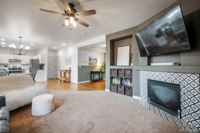 2204 Reed Grass Way, Colorado Springs, CO 80915 - living room with light carpet, a tile fireplace, baseboards, a chandelier, and a ceiling fan