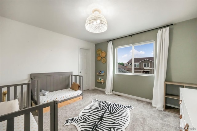 2204 Reed Grass Way, Colorado Springs, CO 80915 - bedroom with carpet floors, baseboards, a chandelier, and a nursery area